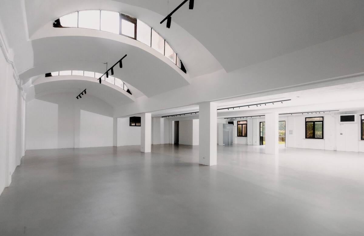 Open space contemporaneo con soffitti a volta e finiture total white