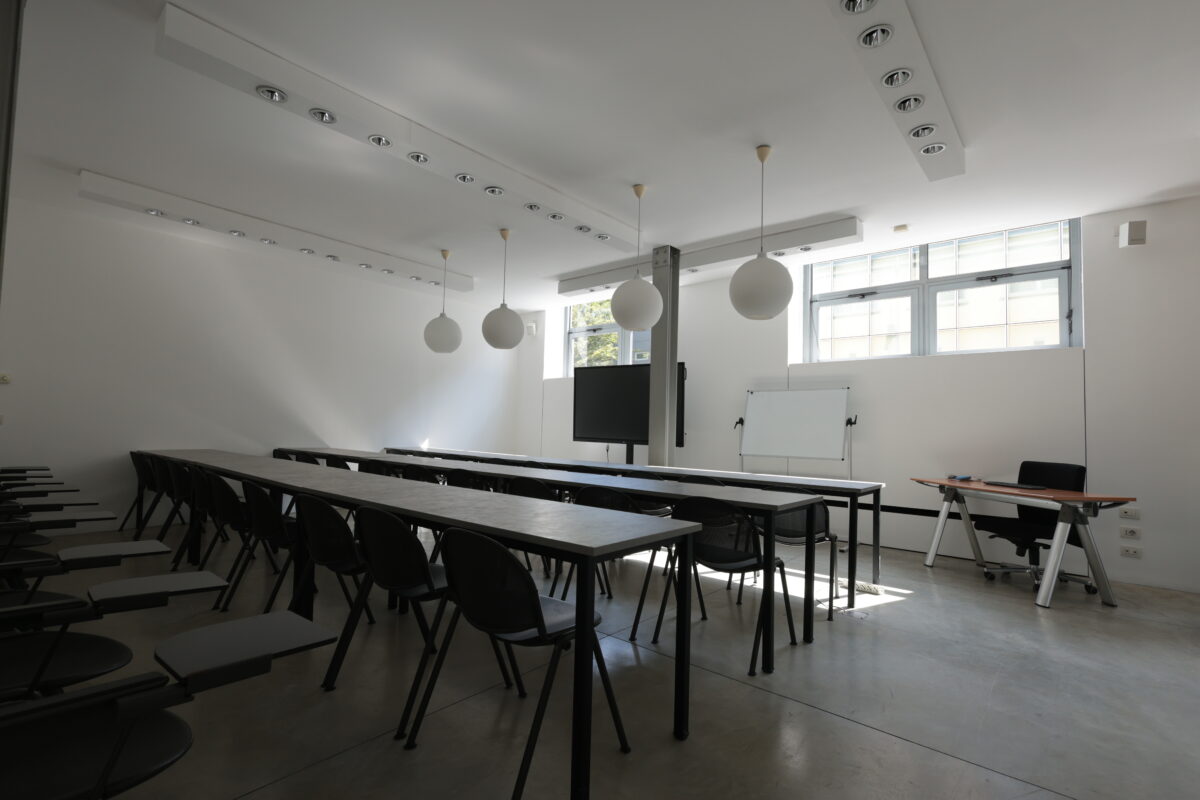 sala meeting con tavoli neri e proiettore